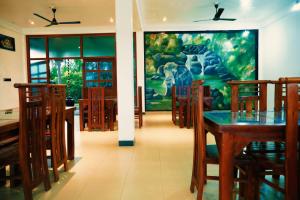 a dining room with a painting on the wall at Discovery resort in Ratnapura