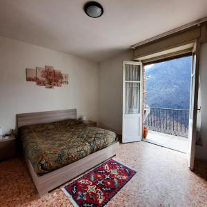 - une chambre avec un lit et une porte donnant sur un balcon dans l'établissement Appartamento Legnone - Your Mountain Holiday, à Tremenico