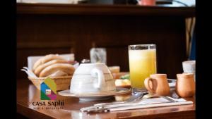 a table with a plate of bread and a glass of orange juice at Casa Saphi in Cusco