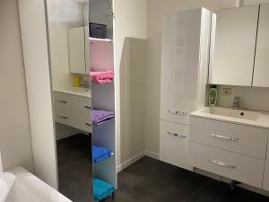 a bathroom with white cabinets and a mirror at Modern Spanish Hacienda - 10km from the coast in Ichtegem