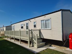 a mobile home with a porch and stairs at 6 Berth central heated The Grange (Balmoral II) in Ingoldmells
