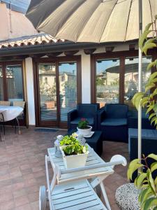 a patio with a table and chairs and an umbrella at Gabriel’s Home in Salò