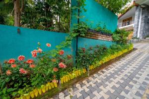 a garden with flowers against a blue wall at 3 Arch Resort Ella in Ella