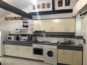 a kitchen with white cabinets and a washer and dryer at La casita de mi abuela in Santo Domingo de la Calzada