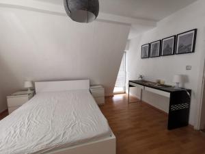 een witte slaapkamer met een bed en een bureau bij Tolles Möbliertes Zimmer in WG Haus in Ulm nähe Uni und Uni-Klinik in Ulm