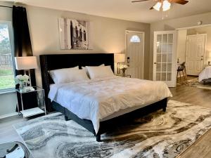 a bedroom with a large bed and a rug at Blue-Door RESIDENCE @Maywood in San Antonio