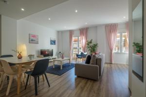 Modern, Stylish Apartment في فالنسيا: غرفة معيشة مع طاولة وغرفة طعام