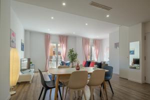 a living room with a dining room table and chairs at Modern, Stylish Apartment in Valencia