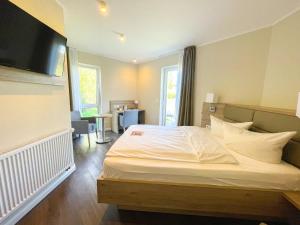 a bedroom with a large white bed in a room at Hotel Saltenhof in Hörstel