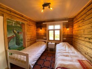 - une chambre avec 2 lits dans une cabane en rondins dans l'établissement Sepa farm stay, à Pikavere
