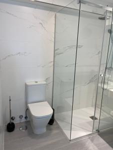 een badkamer met een toilet en een glazen douche bij Campanas Haus in Santiago de Compostela