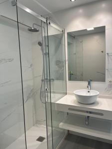 La salle de bains est pourvue d'un lavabo et d'une douche en verre. dans l'établissement Campanas Haus, à Saint-Jacques-de-Compostelle
