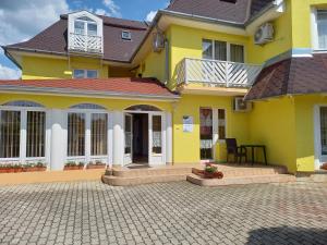 una casa amarilla con un patio delante en Barbara Wellness Pension, en Keszthely