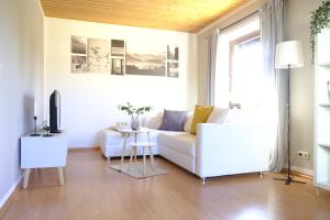 een woonkamer met een witte bank en een tafel bij Ferienhaus am Hainberg in Colditz