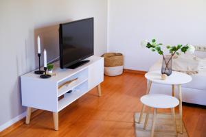 uma sala de estar com uma televisão num armário branco em Ferienhaus am Hainberg em Colditz