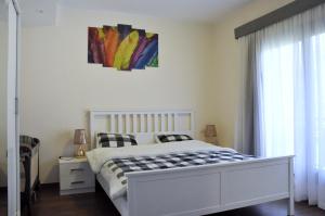 a bedroom with a white bed and a painting on the wall at Axxodia Cairo Festival Residence in Cairo