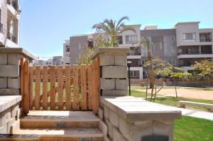 a wooden fence in a yard with buildings in the background at Axxodia Cairo Festival Residence in Cairo