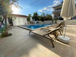 a group of lounge chairs next to a swimming pool at Villa Acar - 4 Bedroom Villa in Dalyan Center, Private Pool&Garden in Mugla