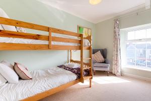 a bedroom with two bunk beds and a chair at Private Parking, Garden, En-suite, 5 Rooms in Llanelli +32 photos