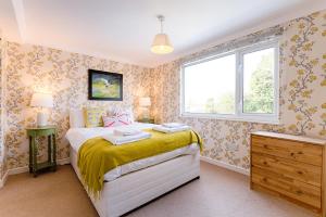 a small bedroom with a bed and a window at Private Parking, Garden, En-suite, 5 Rooms in Llanelli