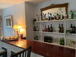 a kitchen with a counter top and a shelf full of wine bottles at Lydgate House Hotel in Postbridge