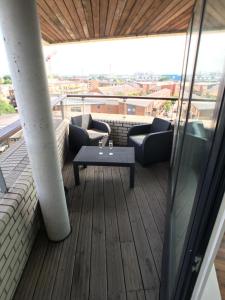 einen Balkon mit Sofas und einem Tisch auf einem Gebäude in der Unterkunft Luxury 2 Bed Penthouse Apartment near station in London