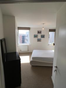 a bedroom with a bed and two windows at Luxury 2 Bed Penthouse Apartment near station in London