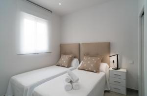 a bedroom with a bed with two white towels on it at AAC Málaga - Apartamento con terraza, muy amplio, totalmente equipado, cerca del centro y nuevo! in Málaga