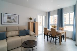 sala de estar con sofá y mesa en AAC Málaga - Apartamento con terraza, muy amplio, totalmente equipado, cerca del centro y nuevo! en Málaga