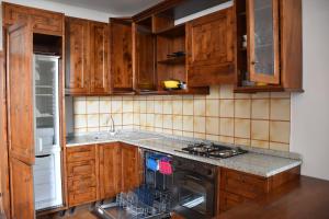 a kitchen with wooden cabinets and a stove top oven at Appartamento Baia Mare in Rosignano Solvay