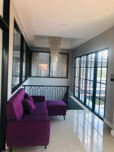 a living room with a purple couch and windows at 243Hotel in Ta Phraya +37 photos