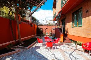 un patio con sillas rojas y una mesa frente a un edificio en Boutique Old City Hotel, en Tiflis