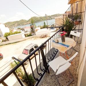 a balcony with a table and chairs and a car at PANSION KONSTANTINOS in Skiathos