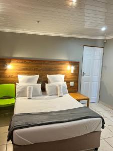 a bedroom with a large bed with a wooden headboard at Hirondelle @ 45 Old Paarl in Bellville