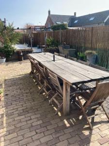 una mesa de picnic de madera con 2 bancos en el patio en Van Zweeden Verhuur, en Biggekerke