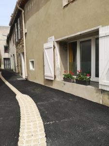 una calle vacía junto a un edificio con dos ventanas en Chez cathe en Rieux-Minervois
