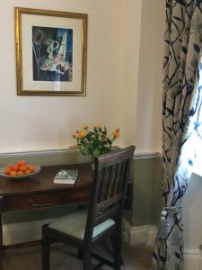 a desk with a chair and a table with a bowl of oranges at The Captain's House in Dartmouth