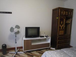 una camera da letto con TV, ventilatore e cassettiera di jazmines point a Lima