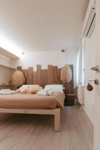 a bedroom with a large bed with a wooden headboard at Laguna Suite B&B in Chioggia