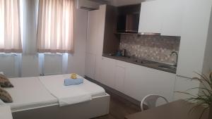 a white kitchen with a sink and a counter at Grand Central Accommodation - Smardan in Bucharest