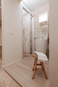 a bathroom with a white tub and a wooden stool at Laguna Suite B&B in Chioggia