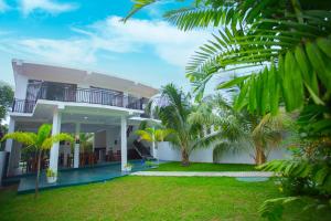 una casa blanca con palmeras delante en Lena Resort en Beruwala