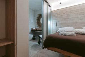 a bedroom with a bed and a bathroom with a mirror at Laguna Suite B&B in Chioggia