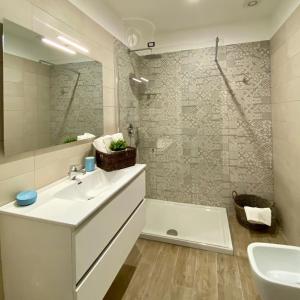 y baño con lavabo, bañera y espejo. en Casa Maria luxury B&B, en Isquia