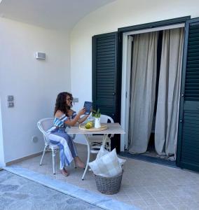 una mujer sentada en una mesa con un portátil en Casa Maria luxury B&B, en Isquia