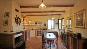 a kitchen and dining room with a table and a fireplace at Casa in campagna oltrepo' pavese in Montecalvo Versiggia