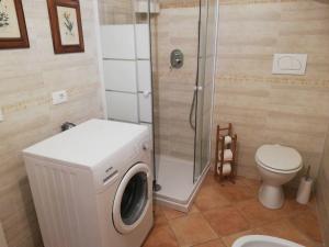 een badkamer met een wasmachine en een toilet bij Casa in campagna oltrepo' pavese in Montecalvo Versiggia