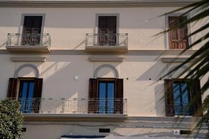 un edificio blanco con balcones y ventanas. en Kalibia rooms and suites, en Mazara del Vallo