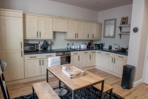 a kitchen with wooden cabinets and a wooden table at Toothbrush Apartments - 2 Bed/2 Bath House with parking, town centre in Ipswich