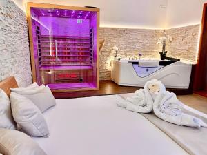 a bedroom with a bed and a tub and a sink at BIRDIE Pension & Wellness in Pardubice